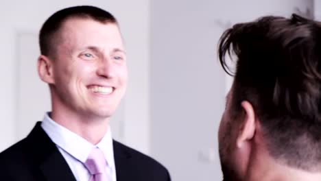 Gay-man-help-his-partner-putting-on-tie-for-job-interview.