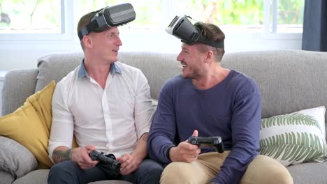 Schwules-Paar-entspannen-dan-auf-der-Couch-spielen-Virtual-Reality-Spiele.-Spaß-im-Wettkampfspiel.