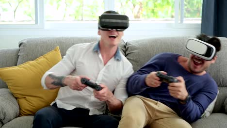 Schwules-Paar-entspannen-dan-auf-der-Couch-spielen-Virtual-Reality-Spiele.-Spannende-Stimmung.