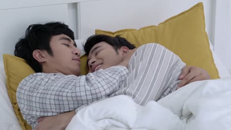 Asian-couple-gay-happy-emotion-morning-in-the-bedroom-at-home.-Gay-boy-lying-on-bed-and-hug-love-anniversary-together.-Concept-of-lifestyle,-family,-gay-and-bisexual.