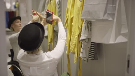 Stylish-Woman-in-Wheelchair-Taking-Selfie-at-Clothing-Store