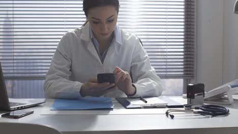 Doctor-working-in-the-office-and-using-a-smartphone