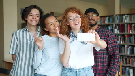 Porträt-glücklicher-Schüler,-die-Selfie-in-der-Bibliothek-mit-Smartphone-Kamera-machen