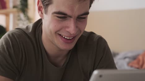 Joyful-man-using-digital-tablet-at-home