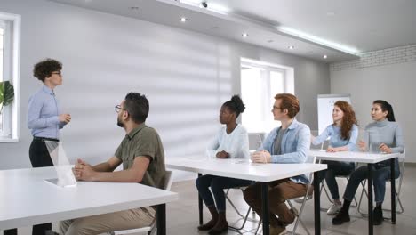 Junge-Studentin-stellt-Lehrerfrage-im-futuristischen-College-Klassenzimmer