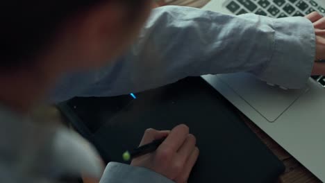 closeup-womans-hands-with-pen-tablet-and-laptop.-woman-freelancer-retoucher-working-at-home