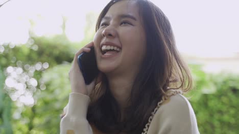 Close-up-shot-of-4K-footage-of-young-asian-woman-using-mobile-with-happy.