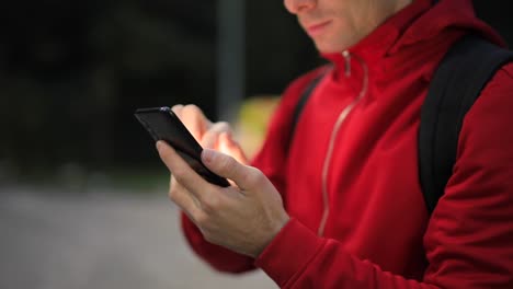 Nicht-wiedererkennbare-Person-mit-Smartphone-im-Park