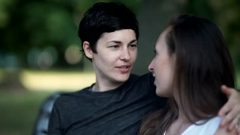 Close-up:-two-lesbians-kisses-on-bench-in-park