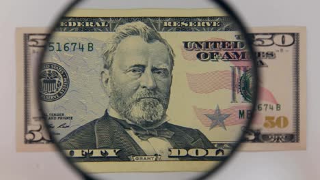 Approaching-using-a-magnifying-glass-fifty-dollar-bill