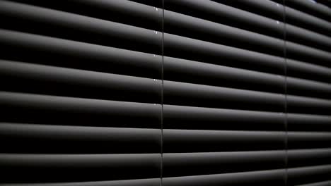 Light-from-the-window-penetrates-into-the-dark-room-through-the-blinds.-Close-up