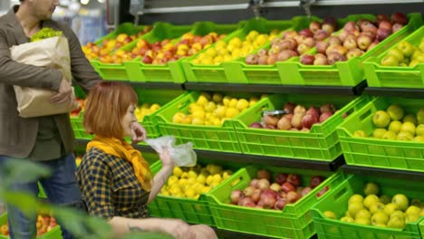 Frau-im-Rollstuhl-mit-Ehemann-in-Produce-Abteilung-einkaufen