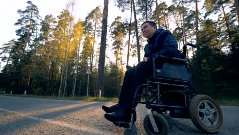 One-man-sits-in-a-black-wheelchair.