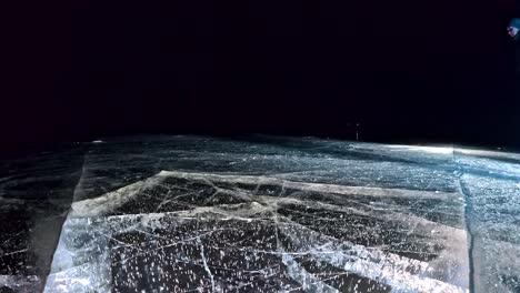 Family-is-ice-skating-night.-Girls-and-boys-to-ride-figure-ice-skates-in-nature.-Mother,-father,-daughter-and-son-riding-together-on-ice-in-cracks.-Outdoor-winter-fun-for-athlete-nice-winter-weather.