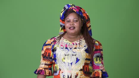 Overweight-beautiful-African-woman-wearing-traditional-clothing-against-green-background