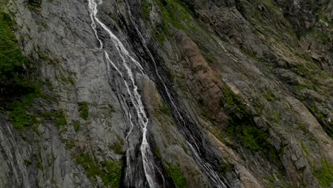 Tracking-and-top-shot-Air-shot-from-a-stream-of-water-splashing-waterfall-on-a-rock-wall-in-the-Caucasus-Mountains.-Around-the-jet-of-the-waterfall