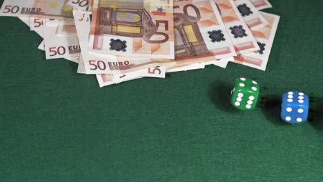 Dice-rolling-against-Green-background-with-50-euros-Bills,-slow-motion