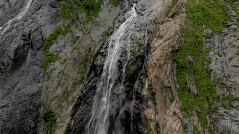 Tracking-and-top-shot-Air-shot-from-a-stream-of-water-splashing-waterfall-on-a-rock-wall-in-the-Caucasus-Mountains.-Around-the-jet-of-the-waterfall