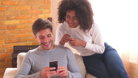 Couple-using-mobile-phone-and-disagree-together-at-home