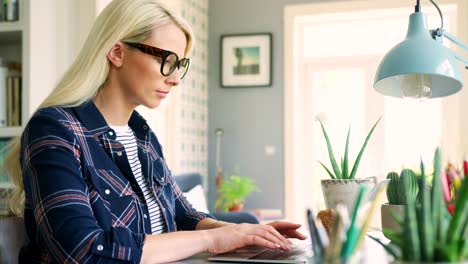 Attractive-Blond-Businesswoman-Typing-On-Laptop-From-Home-Office