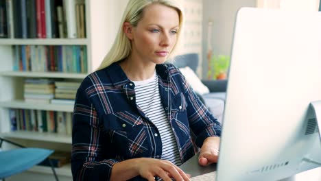 Schöne-blonde-Geschäftsfrau-tippen-am-Computer-zu-Hause-Büro