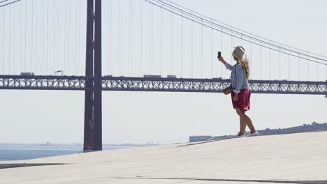 Contemporary-girl-taking-selfie-on-city-embankment