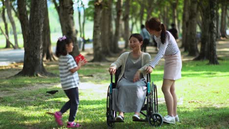 Youngest-daughter-give-red-present-box-for-mother-in-park