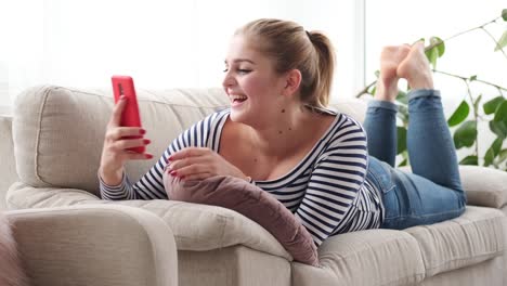 Cheerful-woman-relaxing-and-taking-selfie-using-mobile-phone-camera