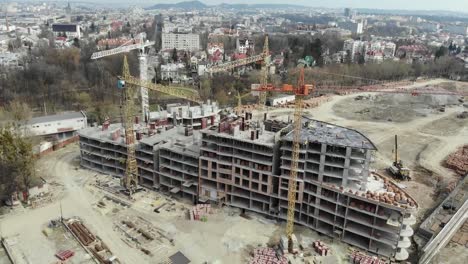 Una-vista-aérea-de-un-edificio-residencial-en-construcción.-Grúas-torre-que-trabajan-en-el-edificio.-4K