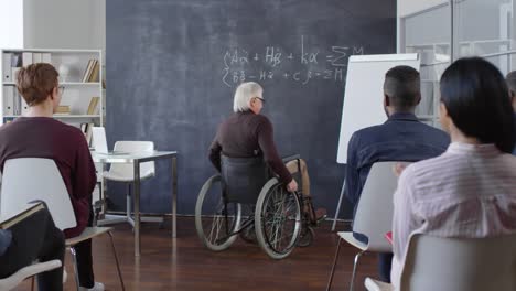 Studenten-begrüßen-Behindertenprofessor-im-Klassenzimmer