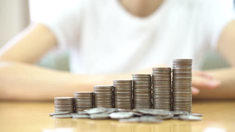 Close-up-Of-woman-Hand-Put-Coins-To-Stack-Of-Coins