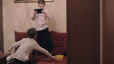 Boy-fooling-and-dancing-when-girl-taking-video-with-tablet-PC