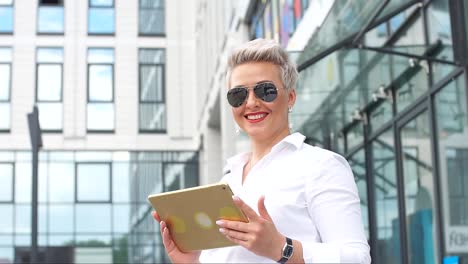 adult-Business-woman-with-tablet-pc-with-office-district-on-background