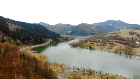 Lago-de-montaña-en-tiempo-nublado-retirado-del-dron.-Hermoso-paisaje-otoñal-con-bosque-y-montañas.