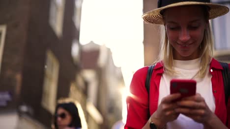 Happy-female-traveler-laughing-at-funny-message-on-smartphone-satisfied-with-international-tariffs-in-roaming