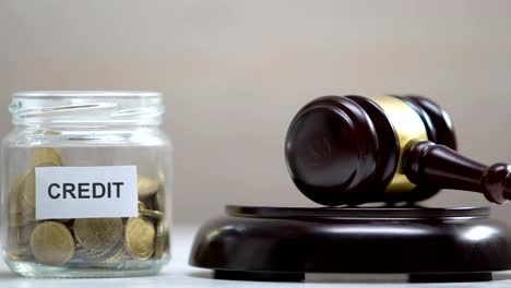 Credit-jar-with-coins,-judge-striking-gavel,-debt-collection,-payment-problems