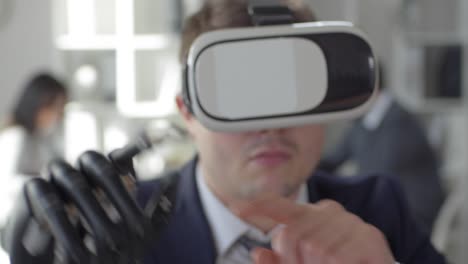 Hombre-de-negocios-con-mano-biónica-usando-gafas-de-realidad-virtual-en-la-oficina