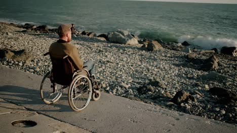 Adult-man-with-paralysis-of-bottom-of-body-is-sitting-in-sea-shore-and-relaxing