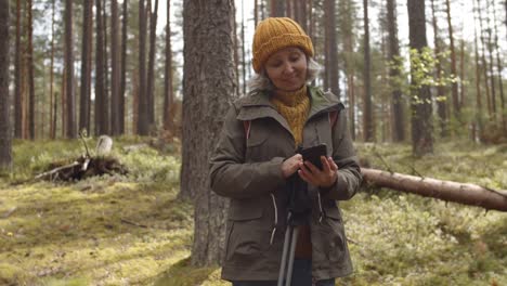 Alte-Frau-macht-Selfie-im-Wald