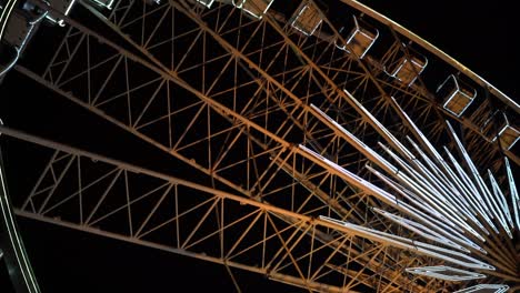 Ferris-wheel.-A-ferris-wheel-rotates-against-the-background-of-the-night-sky.-Close-up-of-a-Ferris-wheel-with-night-illumination.-lluminated-Ferris-Wheel-construction-rotating-against-dark-night-sky-background.