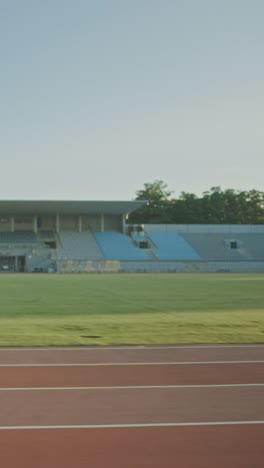 Hermosa-mujer-fitness-en-azul-claro-Atlético-Top-y-Leggings-está-comenzando-una-carrera-de-sprint-en-un-estadio-al-aire-libre.-Atleta-haciendo-su-práctica-deportiva.-A-cámara-lenta.-Video-de-orientación-vertical-de-la-pantalla-9:16