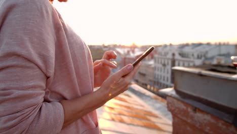 Woman-Using-Phone-on-Building-Roof