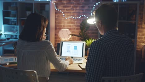 Girl-and-guy-smartphone-interface-designers-working-with-laptop-in-office