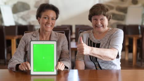 Happy-Mother-And-Daughter-Showing-Digital-Tablet-Together-And-Giving-Thumbs-Up