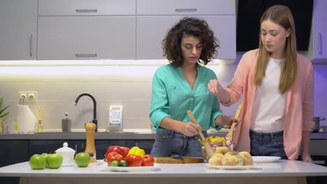 Amigas-mezclando-ensalada-en-tazón-de-vidrio-añadiendo-sal,-culinario,-tiempo-de-calidad