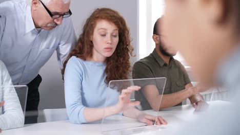 Senior-Male-Teacher-Helping-Students-Perform-Tasks-on-Touchscreen-AR-Devices