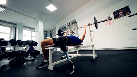 Sala-de-gimnasio-y-un-hombre-con-una-pierna-robótica-levantando-un-bar