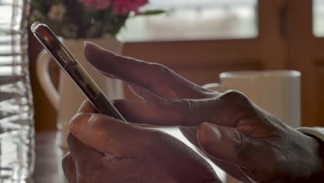 Close-up-of-a-woman's-dark-hands-swiping,-scrolling-and-using-a-smart-phone