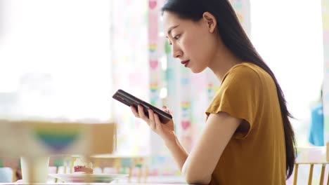 Handheld-view-of-young-woman-enjoying-wireless-internet-at-cafe