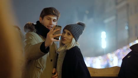 Young-happy-couple-making-winter-selfie-outdoor.